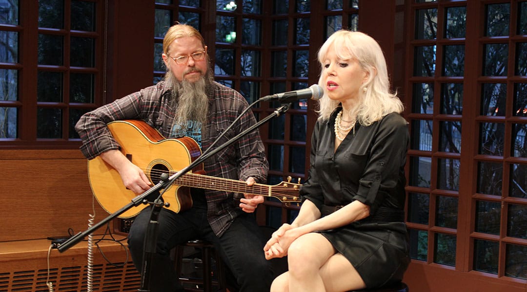 two performers singing and playing guitar