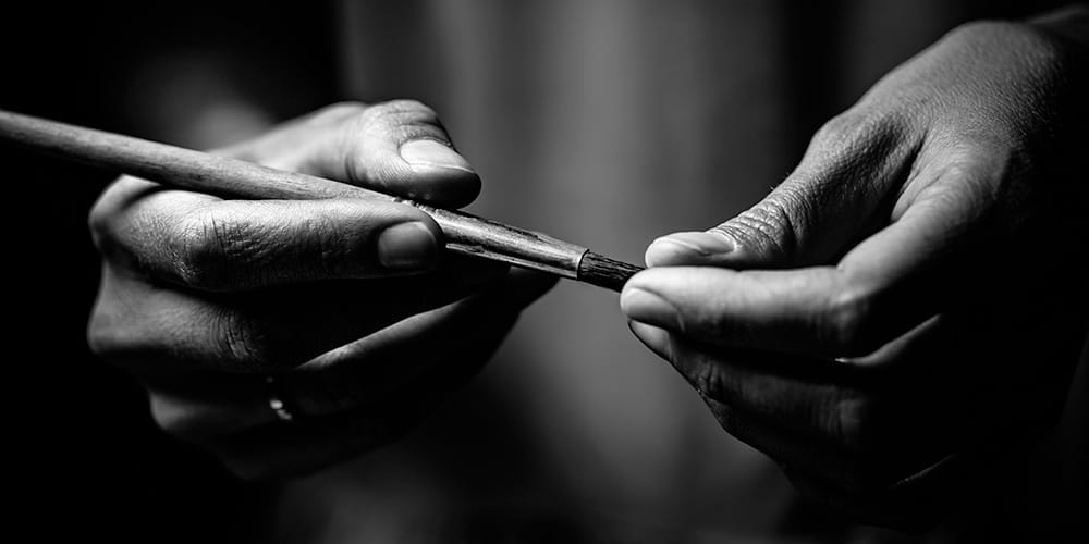 Artist's hands holding paintbrush