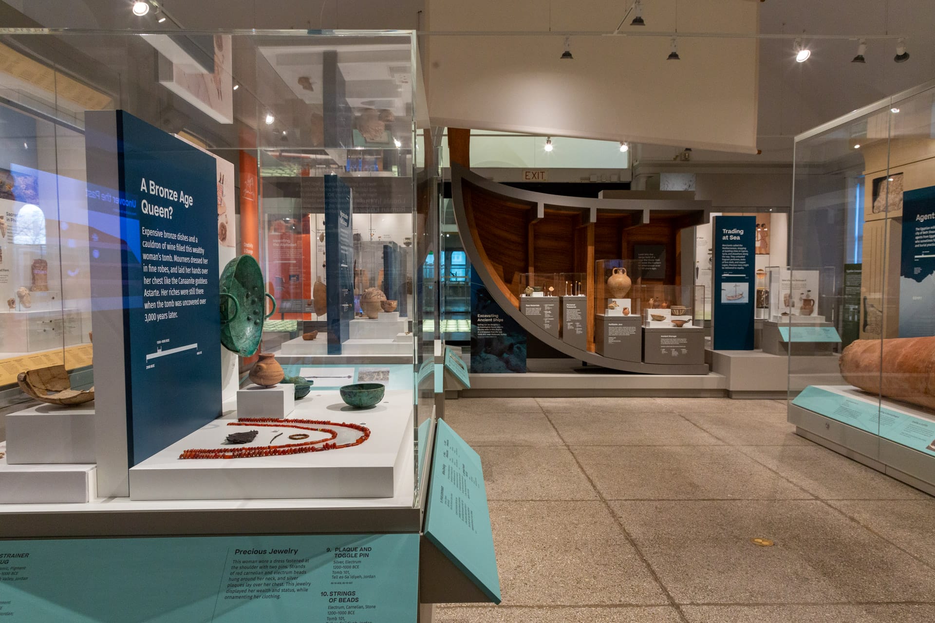 At left, objects from the burial assemblage of a woman of high status illustrate the fine materials available to those in positions of power; these were uncovered in Tall As-Sa'idiyya, Jordan, during an expedition led by Penn Museum archaeologist James Pritchard. In the background, a model of a ship incorporates various types of items found in shipwrecks from antiquity, conveying the ever-present perils of traveling at sea.