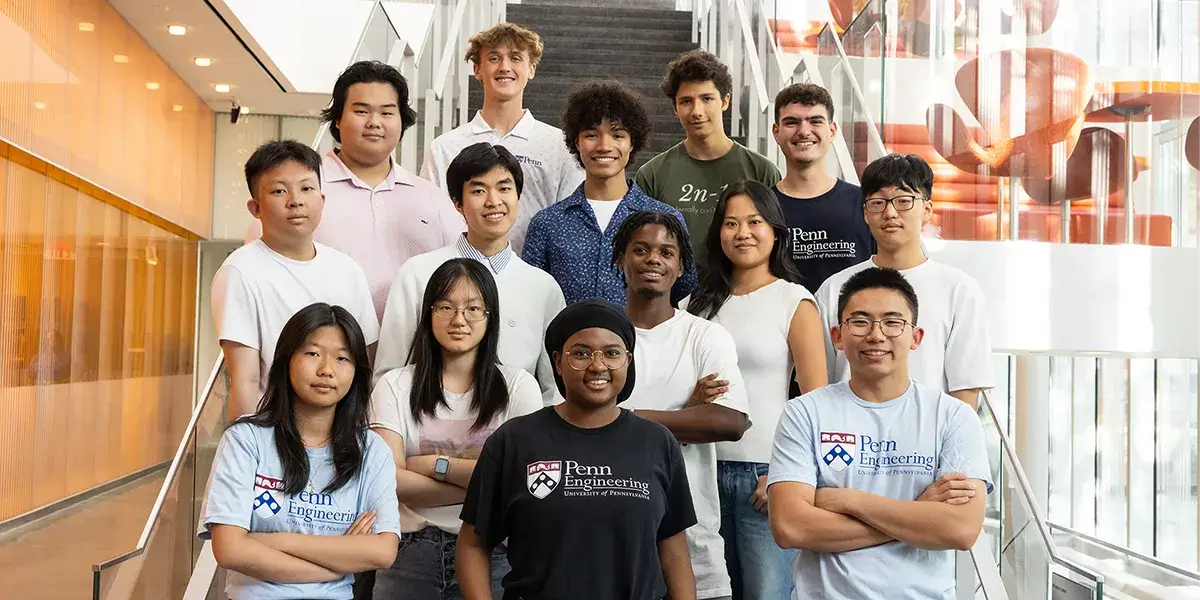 A group of Penn Engineering students standing together inside an academic building.