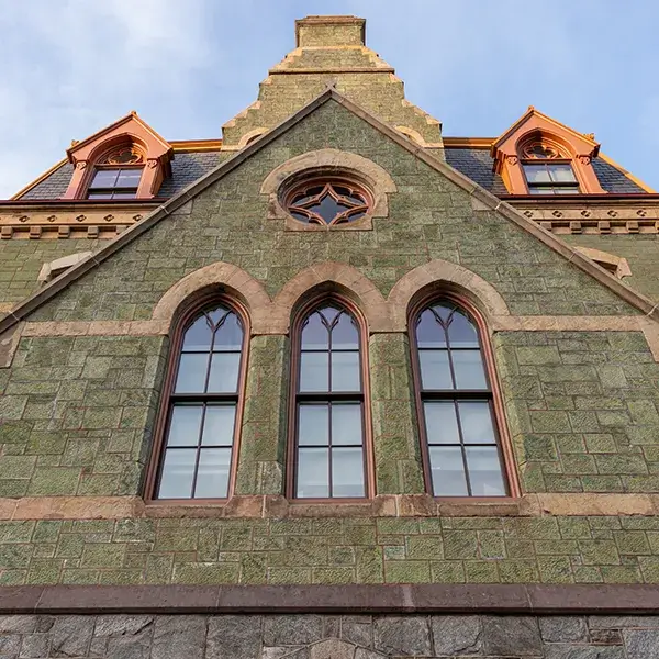 Close-up view of College Hall’s arched windows and stone façade at Penn.