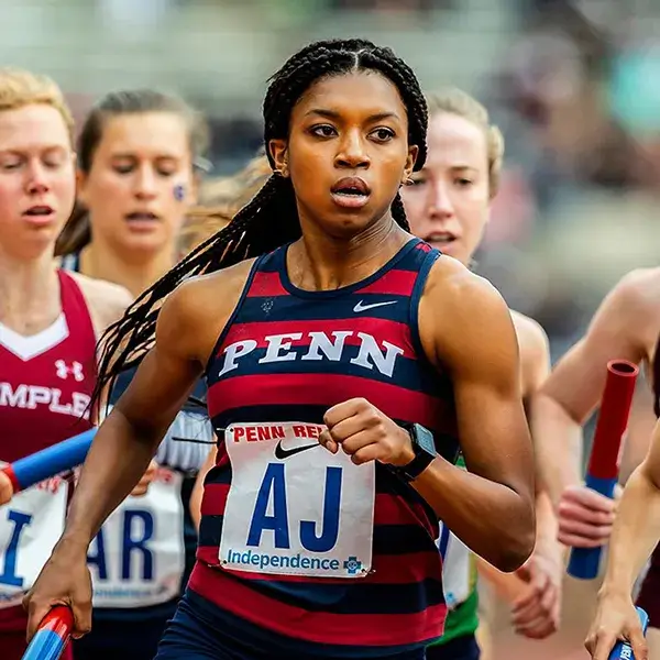 A Penn student-athlete leads the pack during a relay race at the Penn Relays.