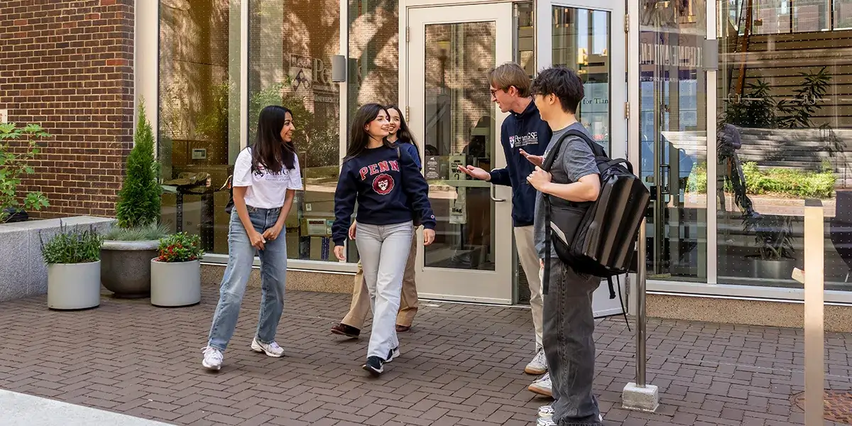 Students and staff talk outside the Penn Graduate School of Education building.