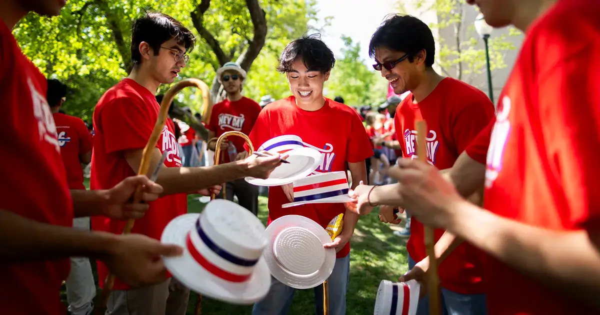 A group of University of Pennsylvania students celebrates Hey Day in matching red shirts and white hats.